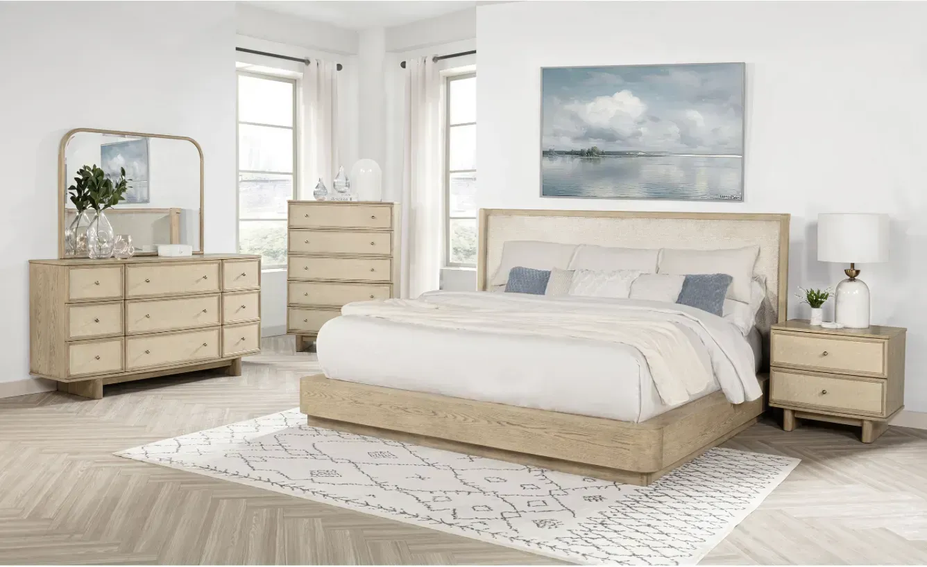 Bedroom set with bed, dresser, chest, mirror, nightstand, and art, light wood, neutral colors.