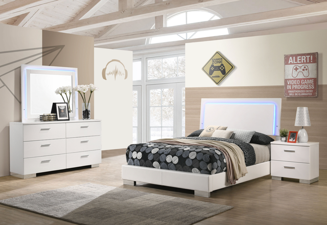 A bedroom with a bed , dresser , nightstand , mirror and rug.