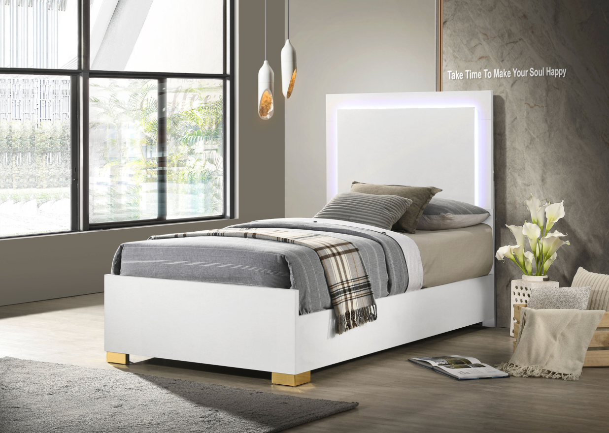 A bedroom with a white bed and a large window.