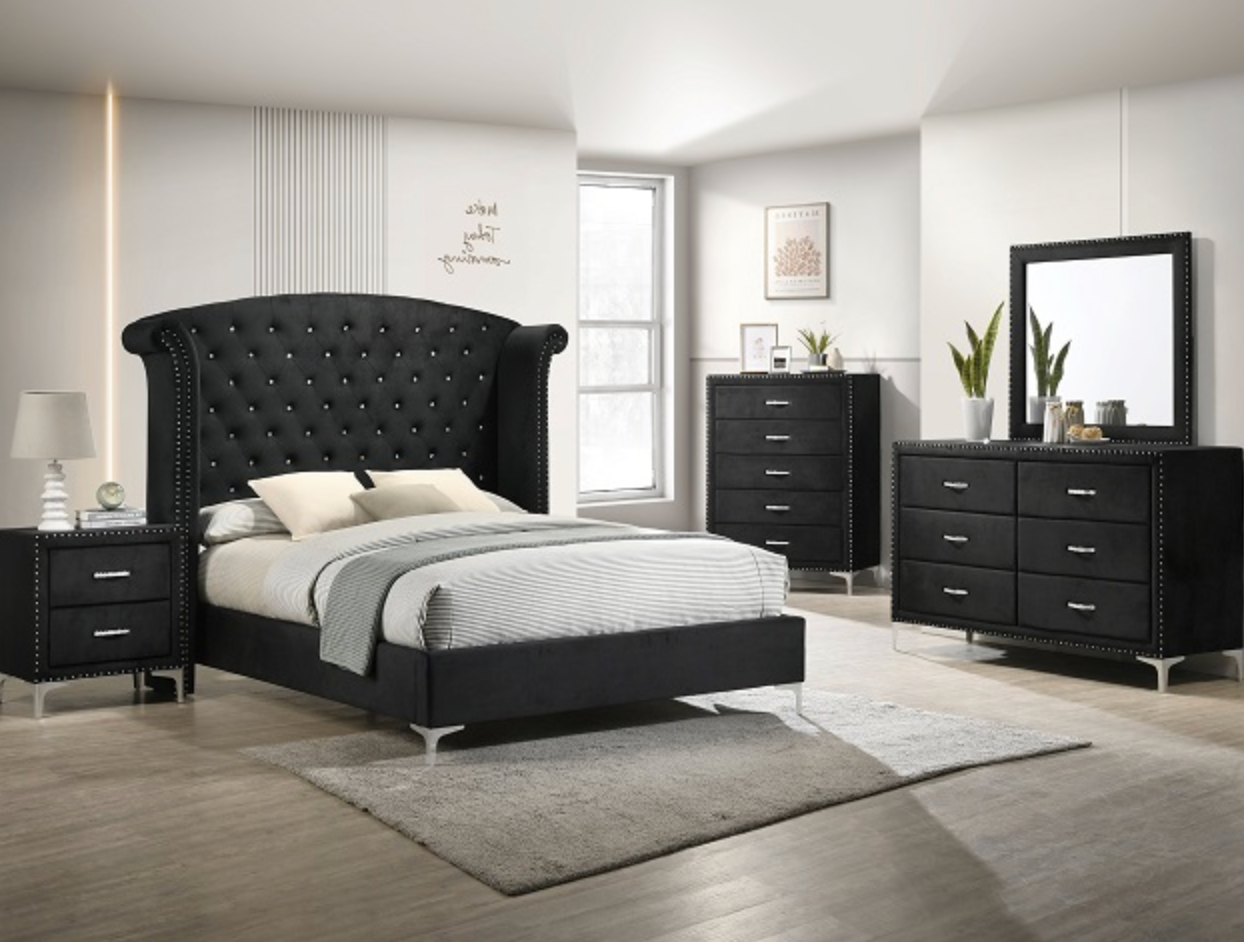 A bedroom with a bed , dresser , nightstand and mirror.
