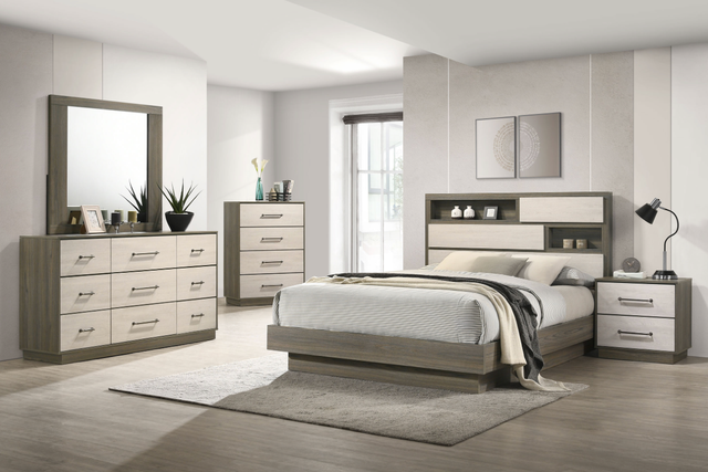 A bedroom with a bed , dresser , nightstand and mirror.
