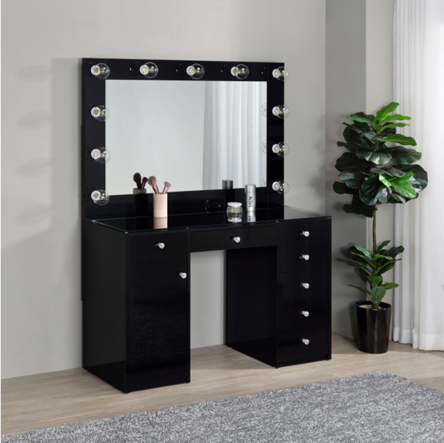 A black vanity with a mirror and lights on it