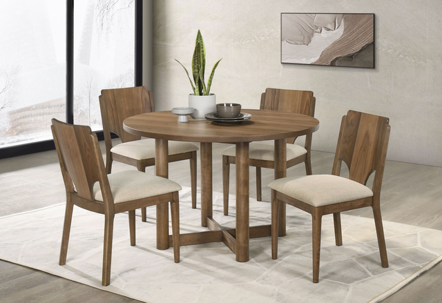 A round wooden dining table with four chairs in a room.