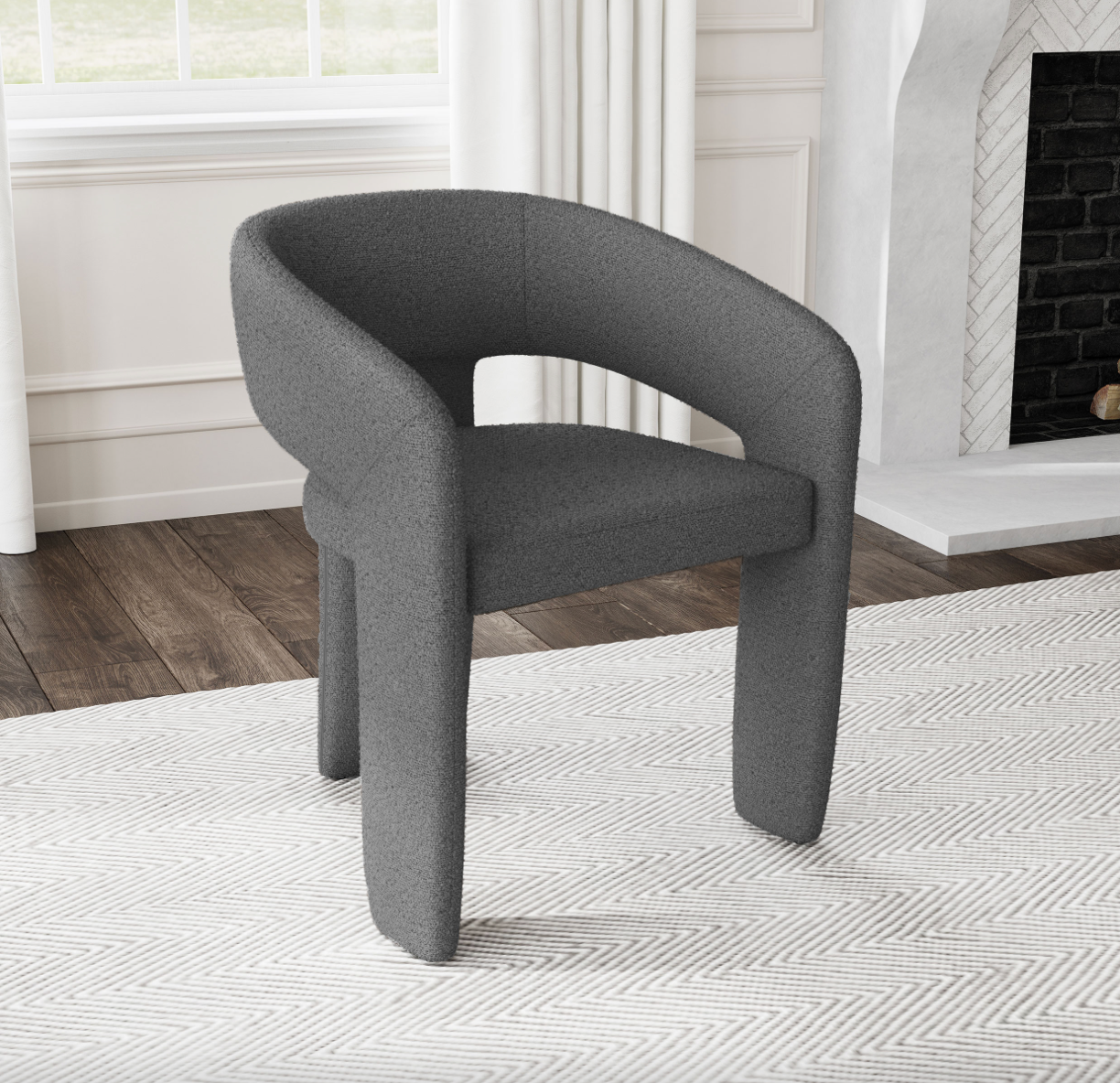 A gray chair is sitting on a white rug in a living room next to a fireplace.