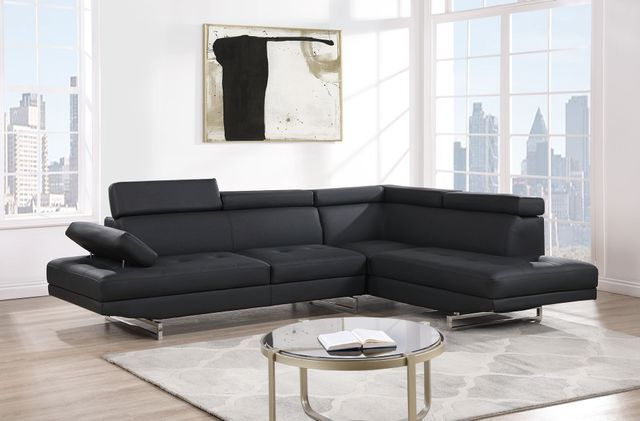 A living room with a black sectional couch and a coffee table