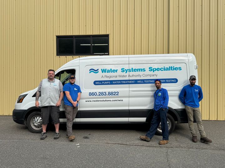 A group of men are standing in front of a white van.