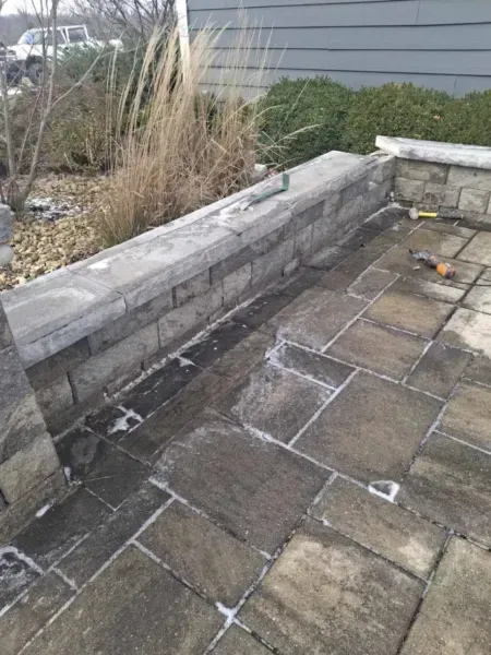 Stone patio with a stone wall and weathered appearance.