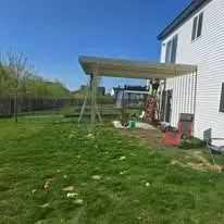 A covered patio is being built in the backyard of a house.