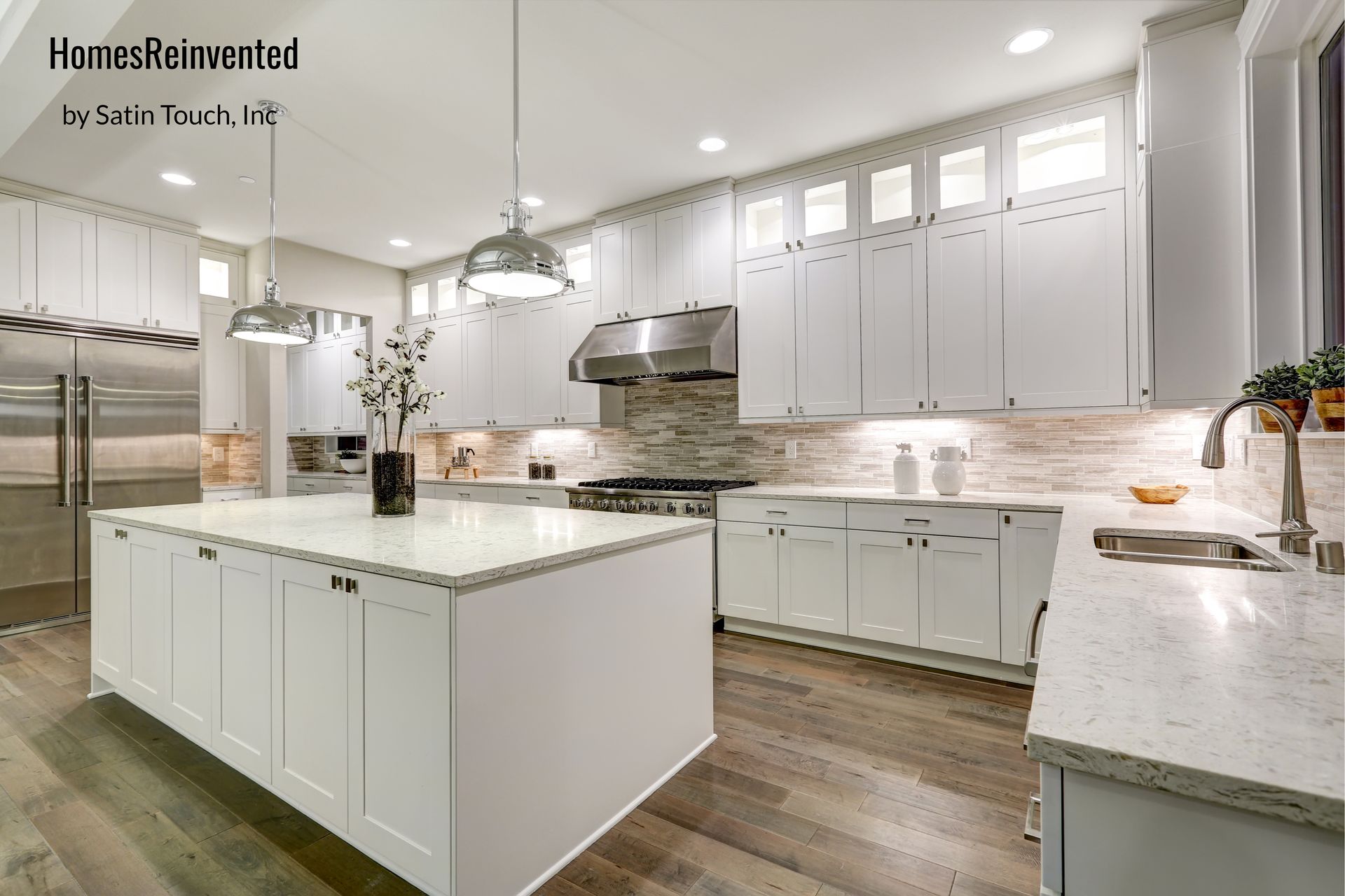 White kitchen with island, cabinets, stainless steel appliances, and hardwood floor.