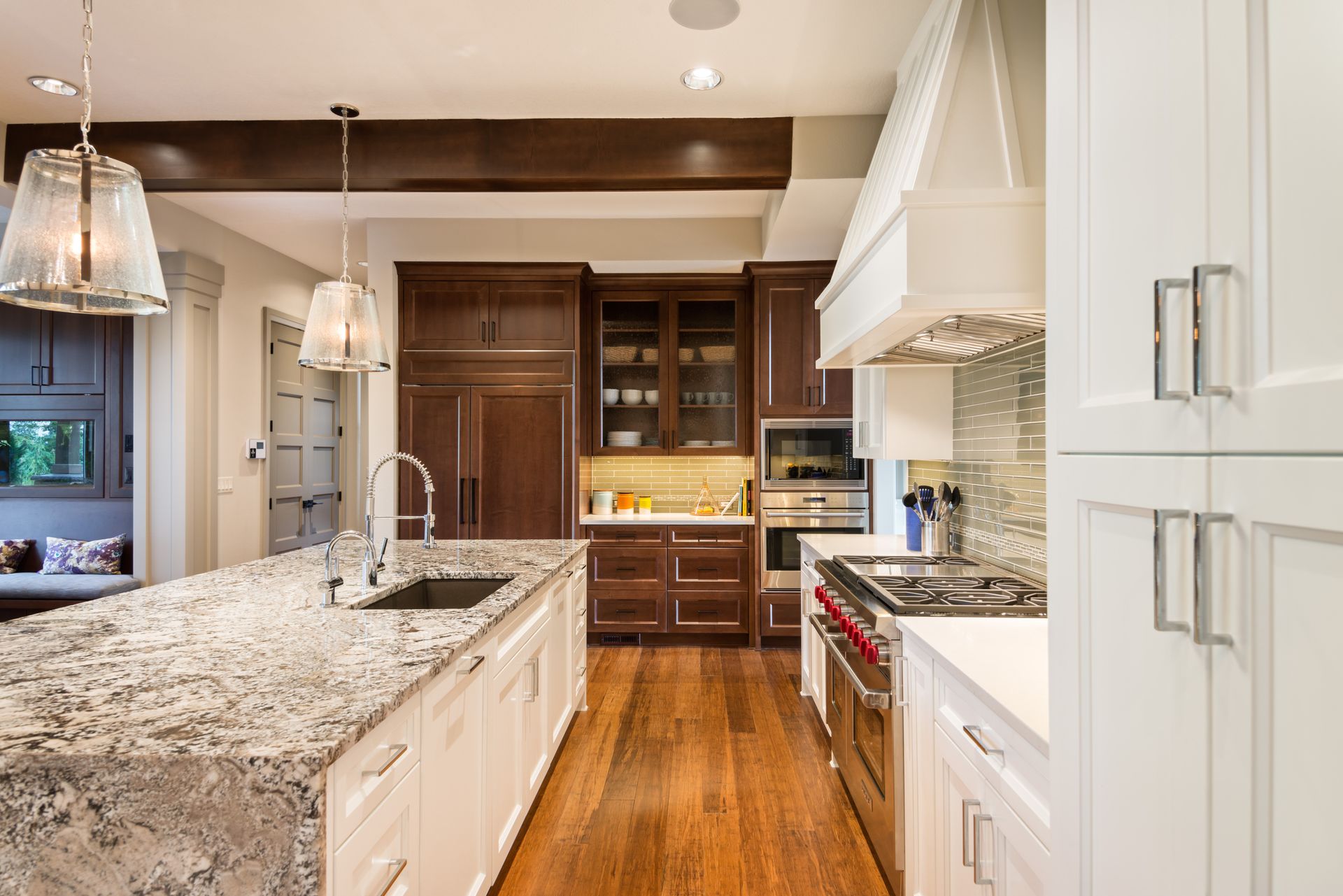 Elegant kitchen with a large island, stainless steel appliances, and dark wood cabinetry.
