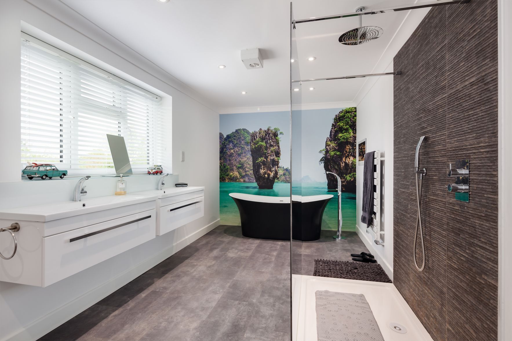 Modern bathroom with a bathtub and a walk-in shower. Gray floor, white walls, and a window with blinds.