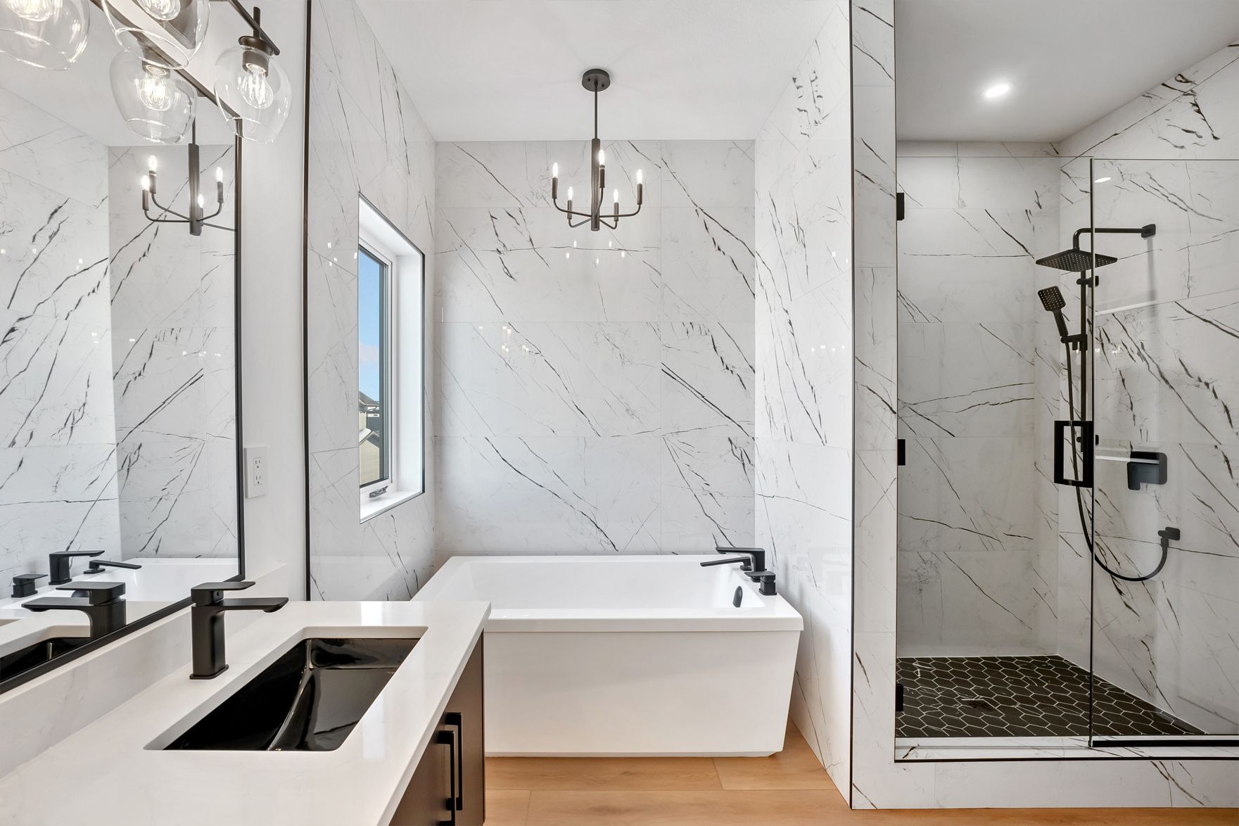 Modern bathroom with white marble walls, black fixtures, and a glass-enclosed shower.