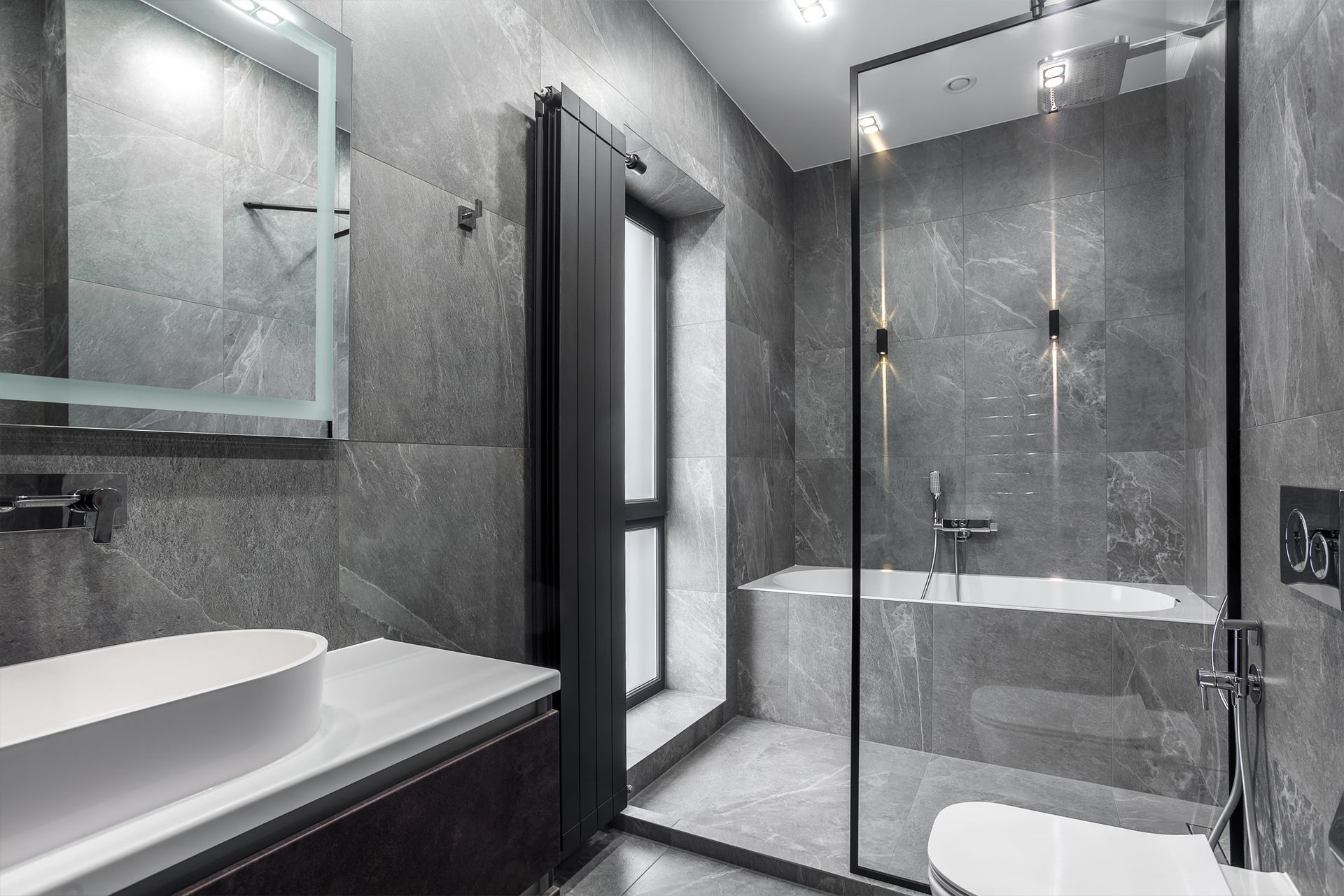 Modern gray bathroom with shower, tub, sink, and toilet.