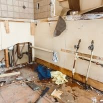 A kitchen is being remodeled and there is a lot of trash on the floor.