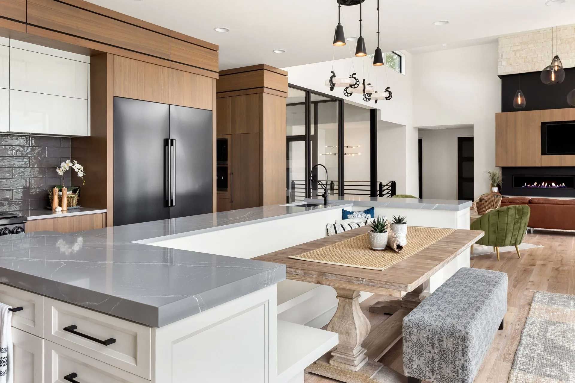 Modern kitchen with light wood cabinetry, large island, and built-in appliances.