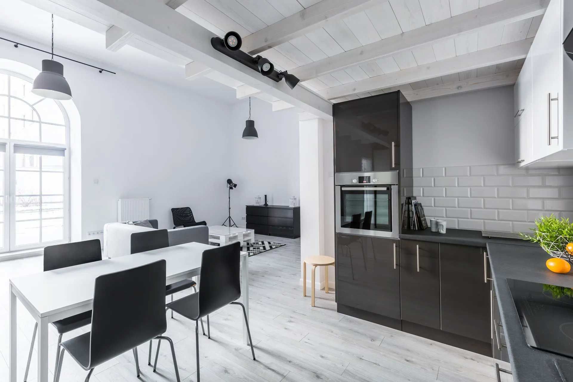 Modern open-plan kitchen and dining area with black and white color scheme.