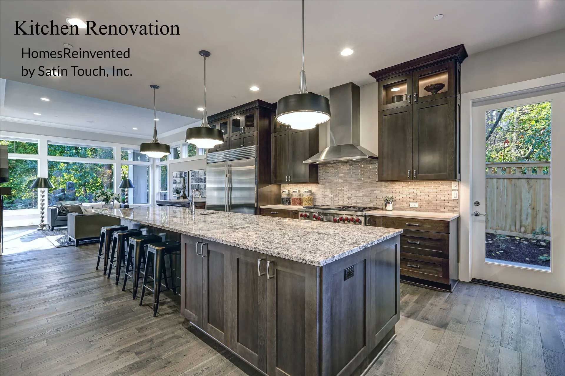 Modern kitchen renovation with island, dark cabinets, and stainless steel appliances.
