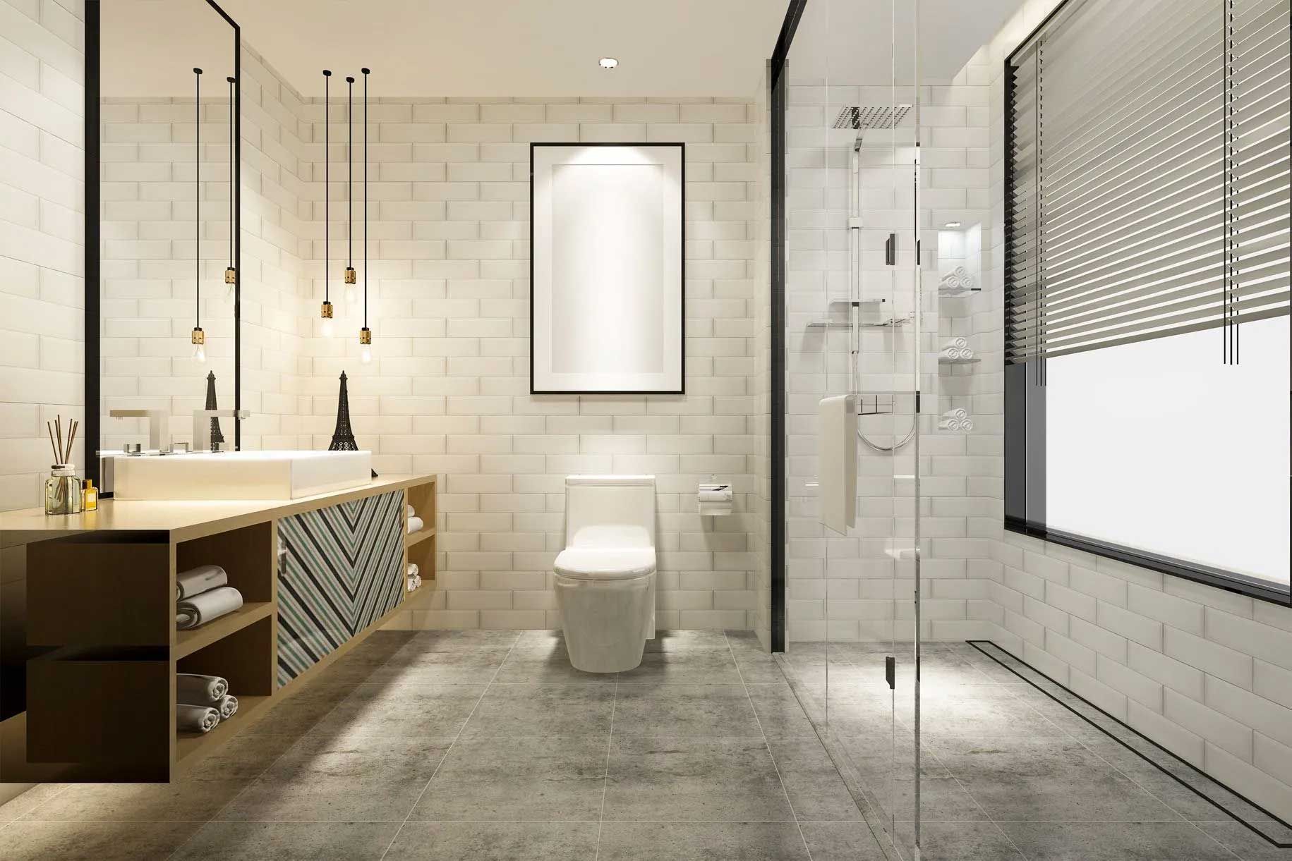 Modern bathroom with white brick walls, shower, toilet, sink, and large window with blinds.