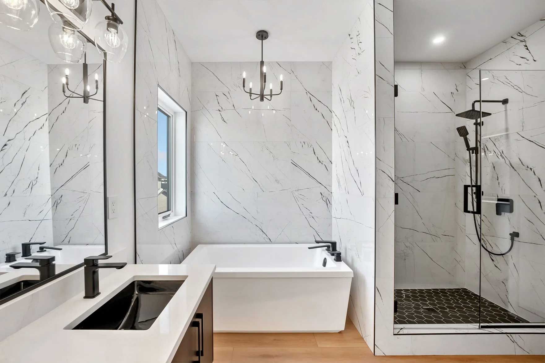Modern bathroom with white and black tile, soaking tub, and walk-in shower.