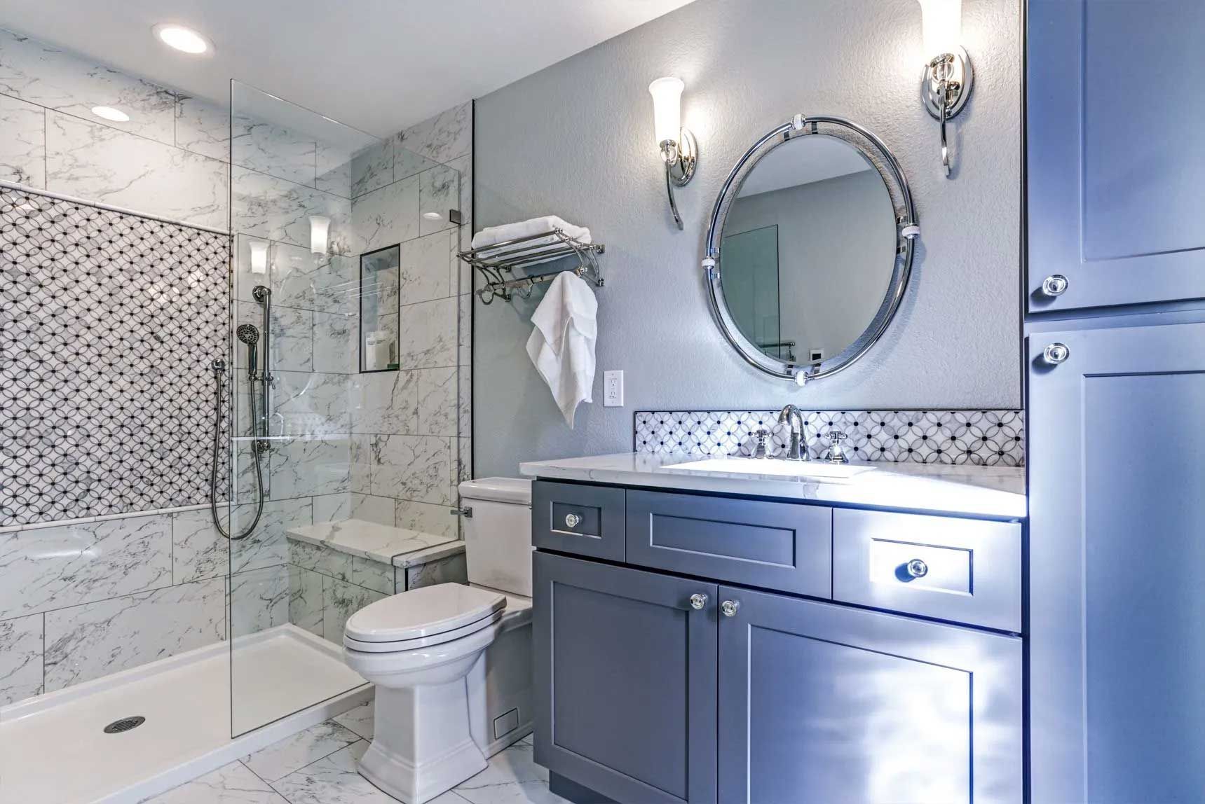 Modern gray and white bathroom with a shower, toilet, vanity, and mirror.
