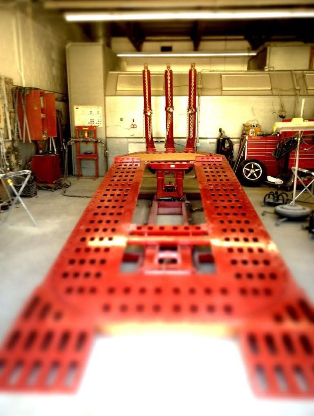 A large red table in a garage with holes in it