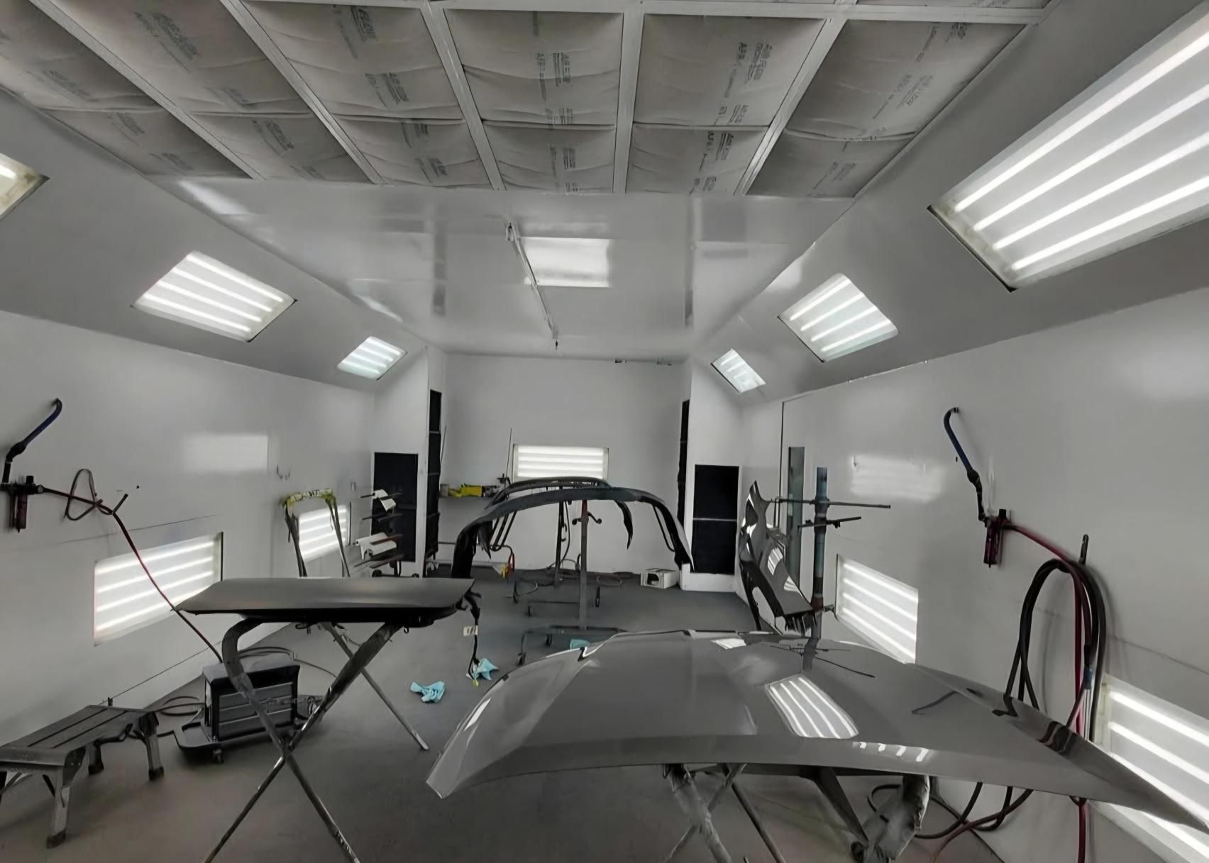 A car is being painted in a paint booth.