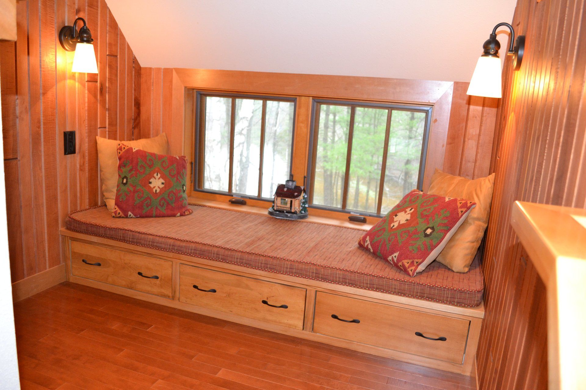 There is a window seat with drawers underneath it.