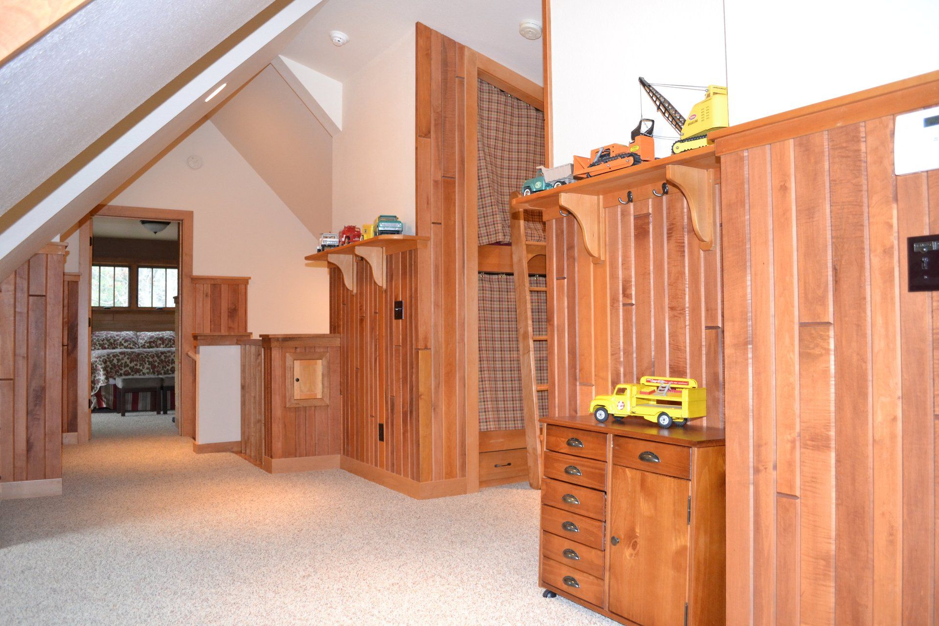 A room with wood paneling and a toy truck on a shelf