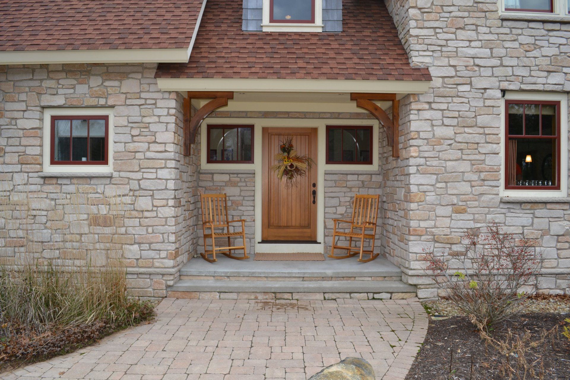 A stone house with two rocking chairs in front of it