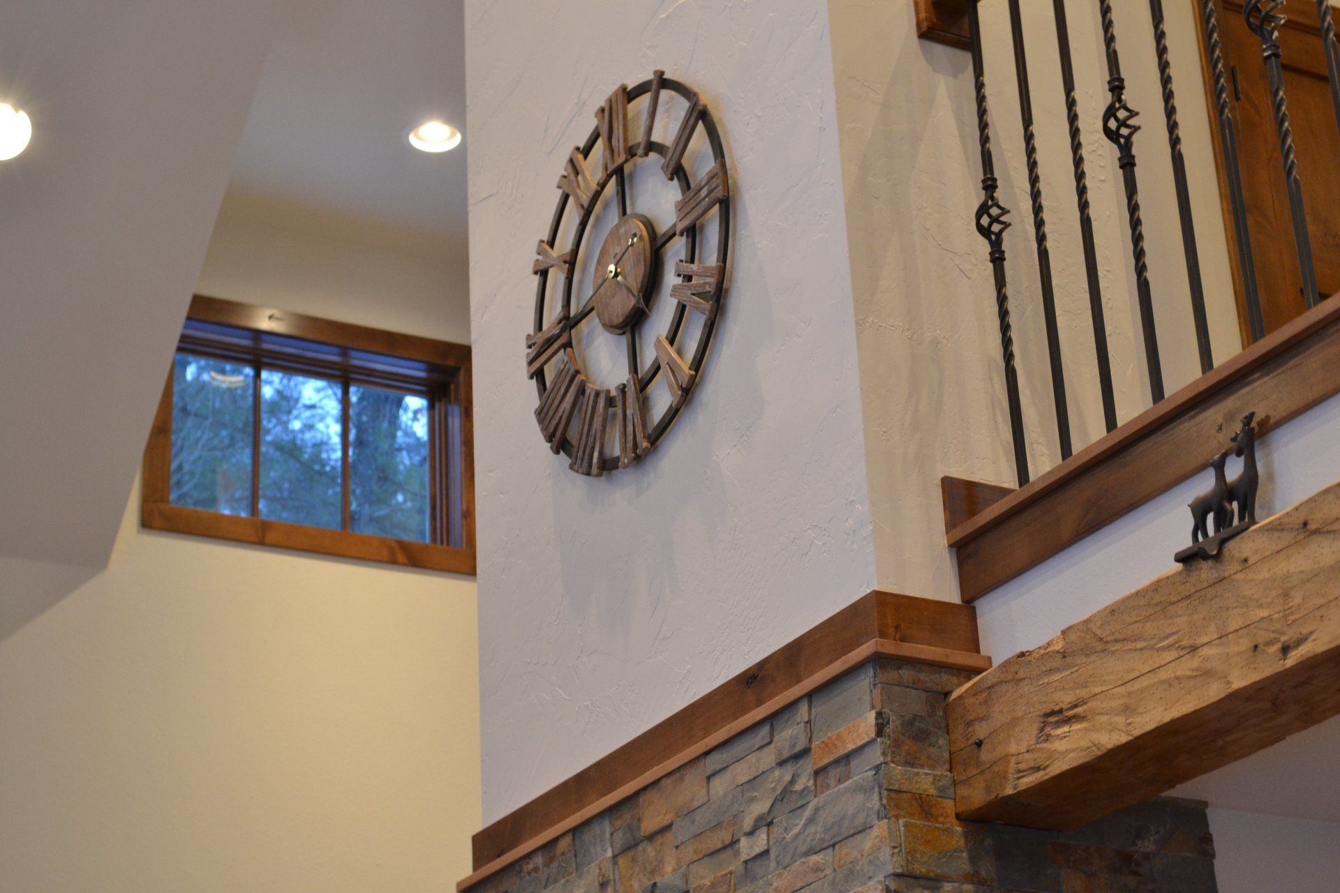 A large clock is hanging on a wall next to a window.