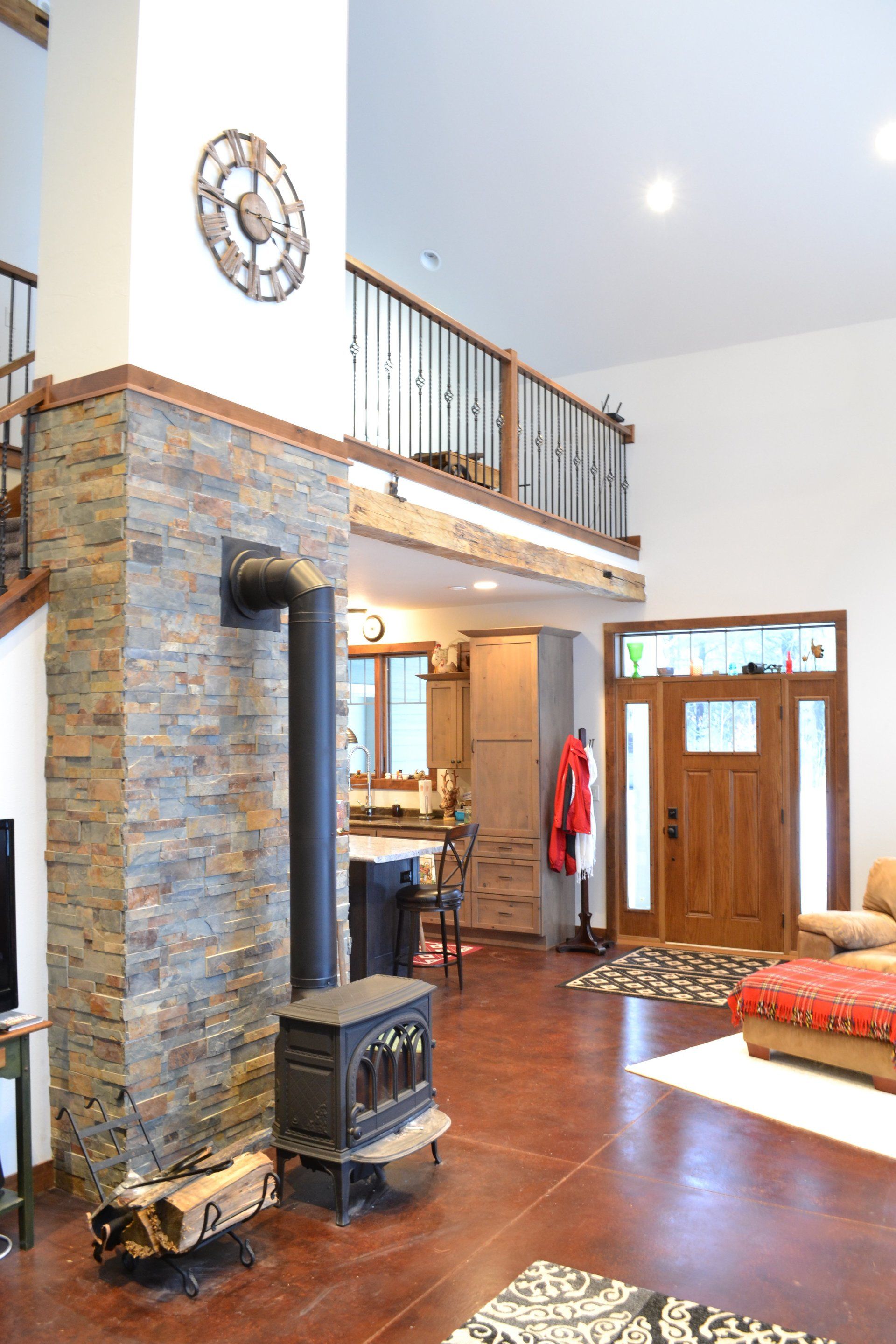 A living room with a wood stove and a clock on the wall.