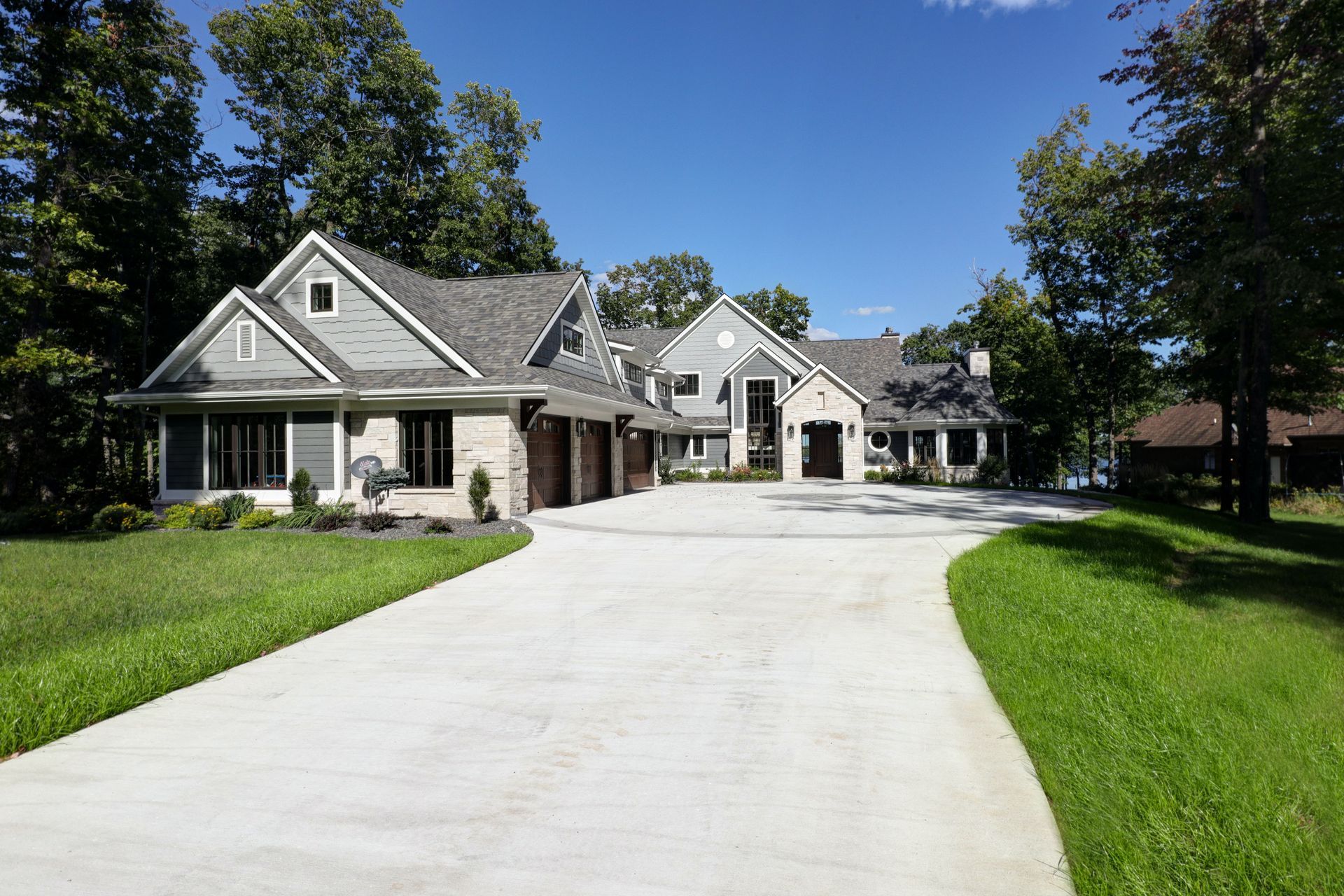 A large house with a concrete driveway leading to it