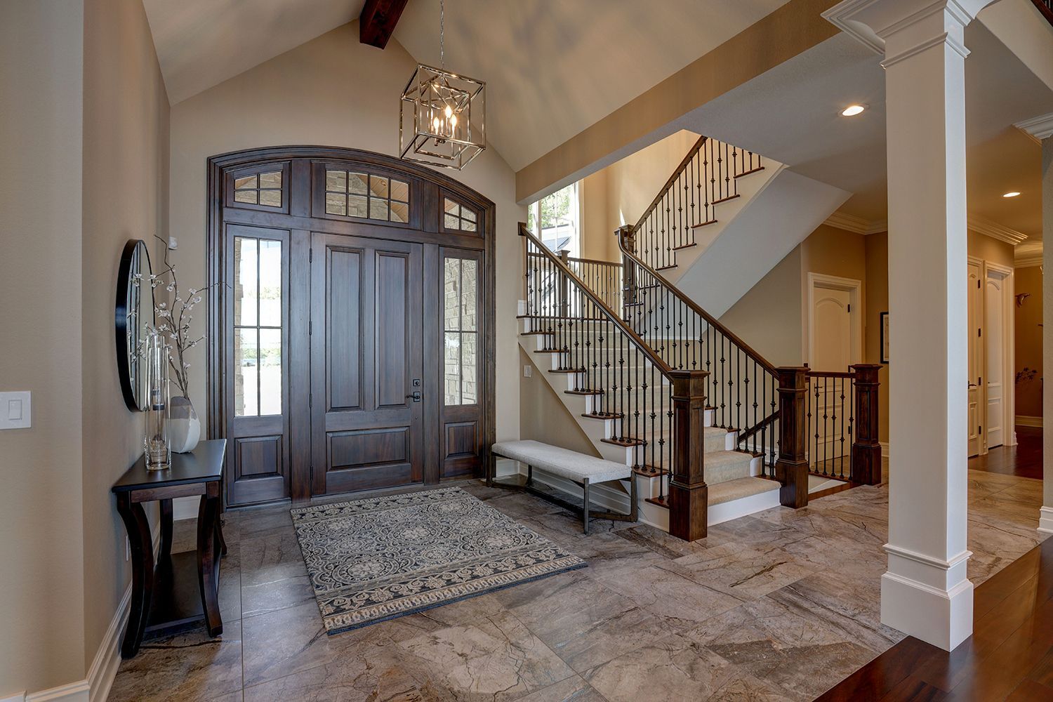 A large hallway with a wooden door and stairs