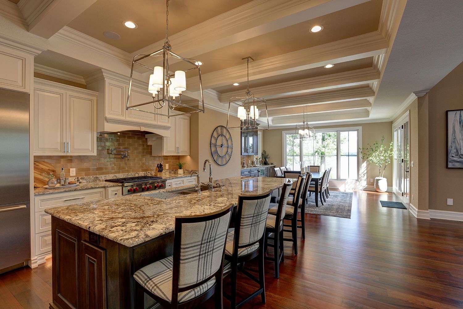 A kitchen with a large island and a clock on the wall.
