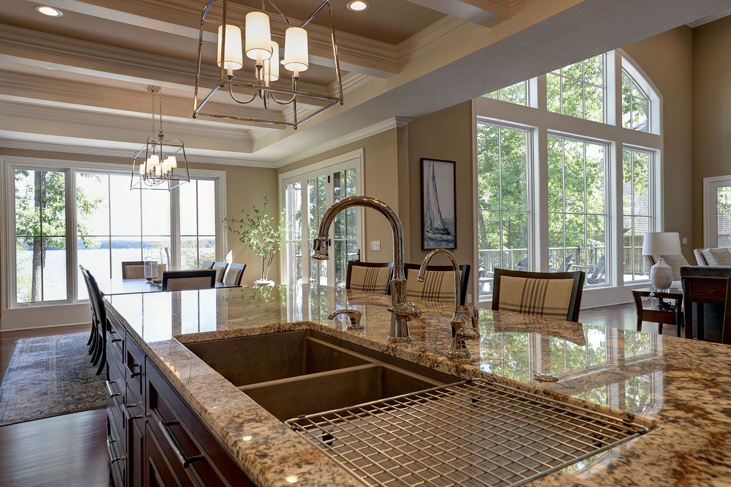 A kitchen with a large sink and granite counter tops