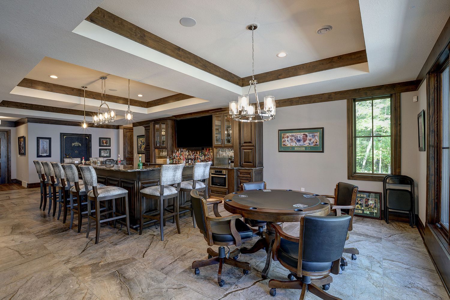 A large room with a table and chairs and a bar.