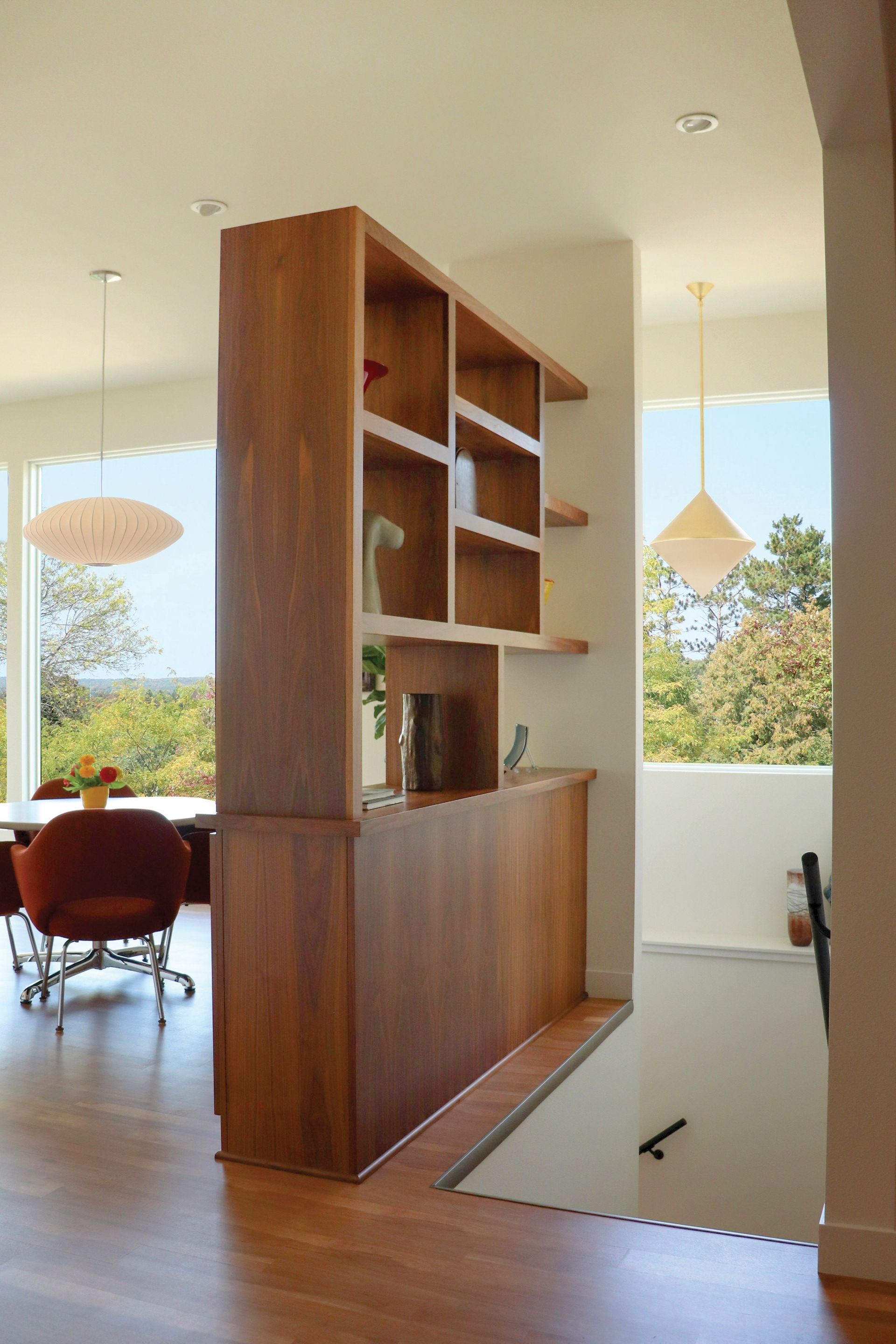 A room with a wooden divider between the dining room and the living room