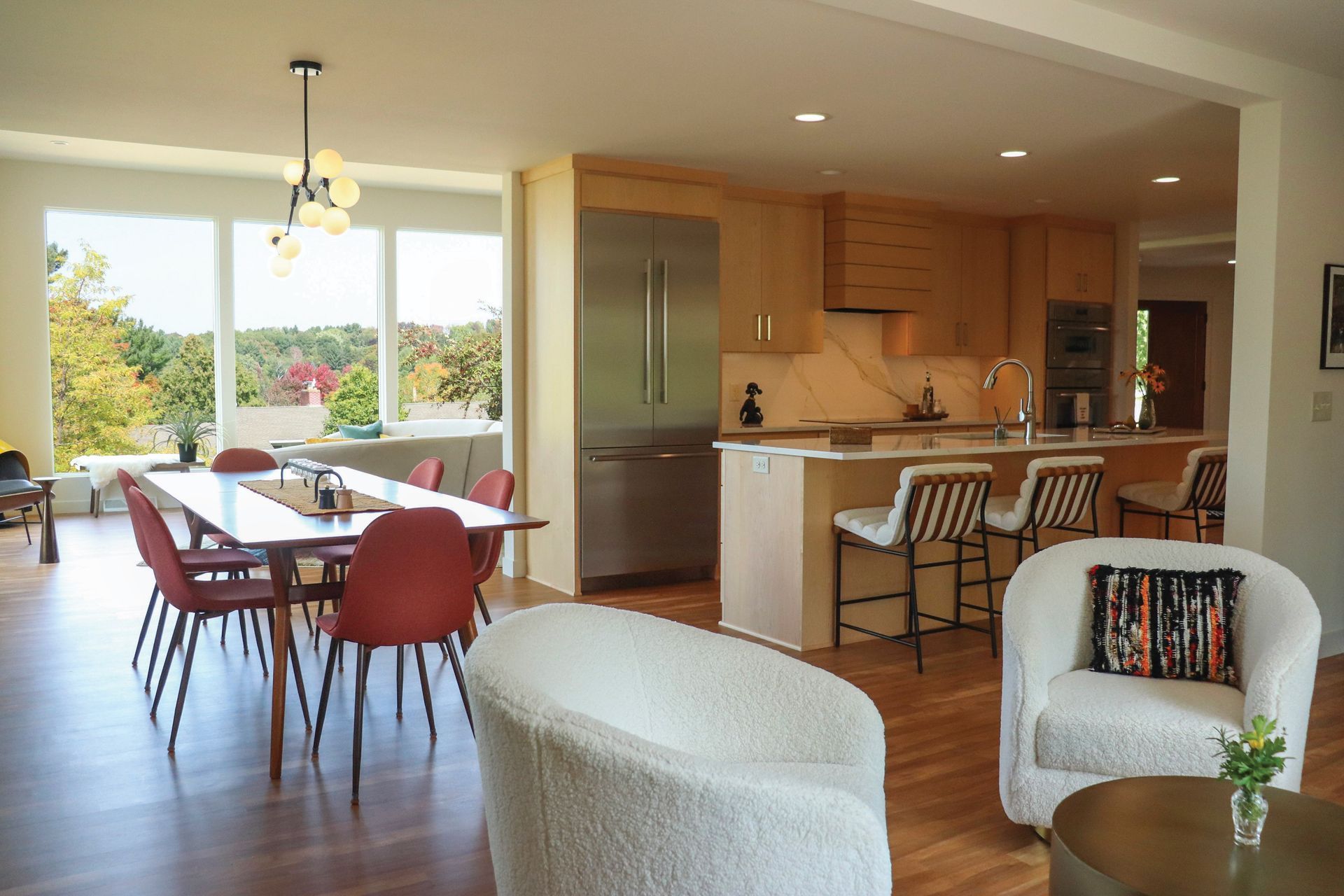 A living room with a table and chairs and a kitchen