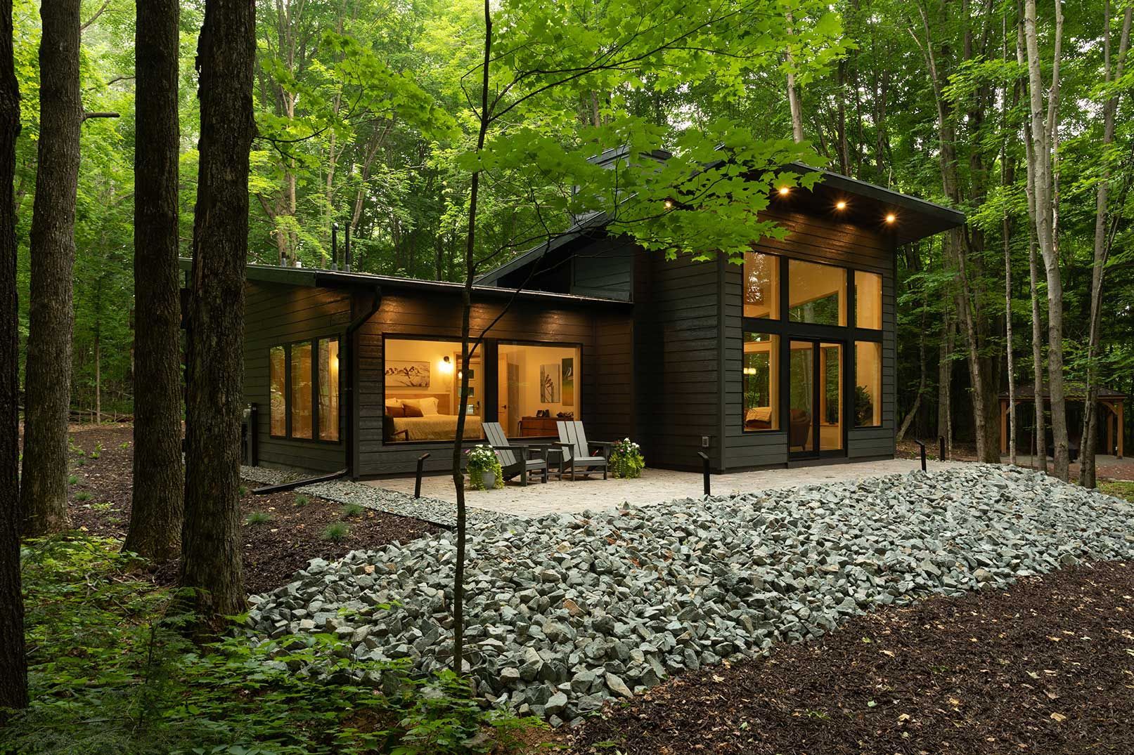 A small house is sitting in the middle of a forest.