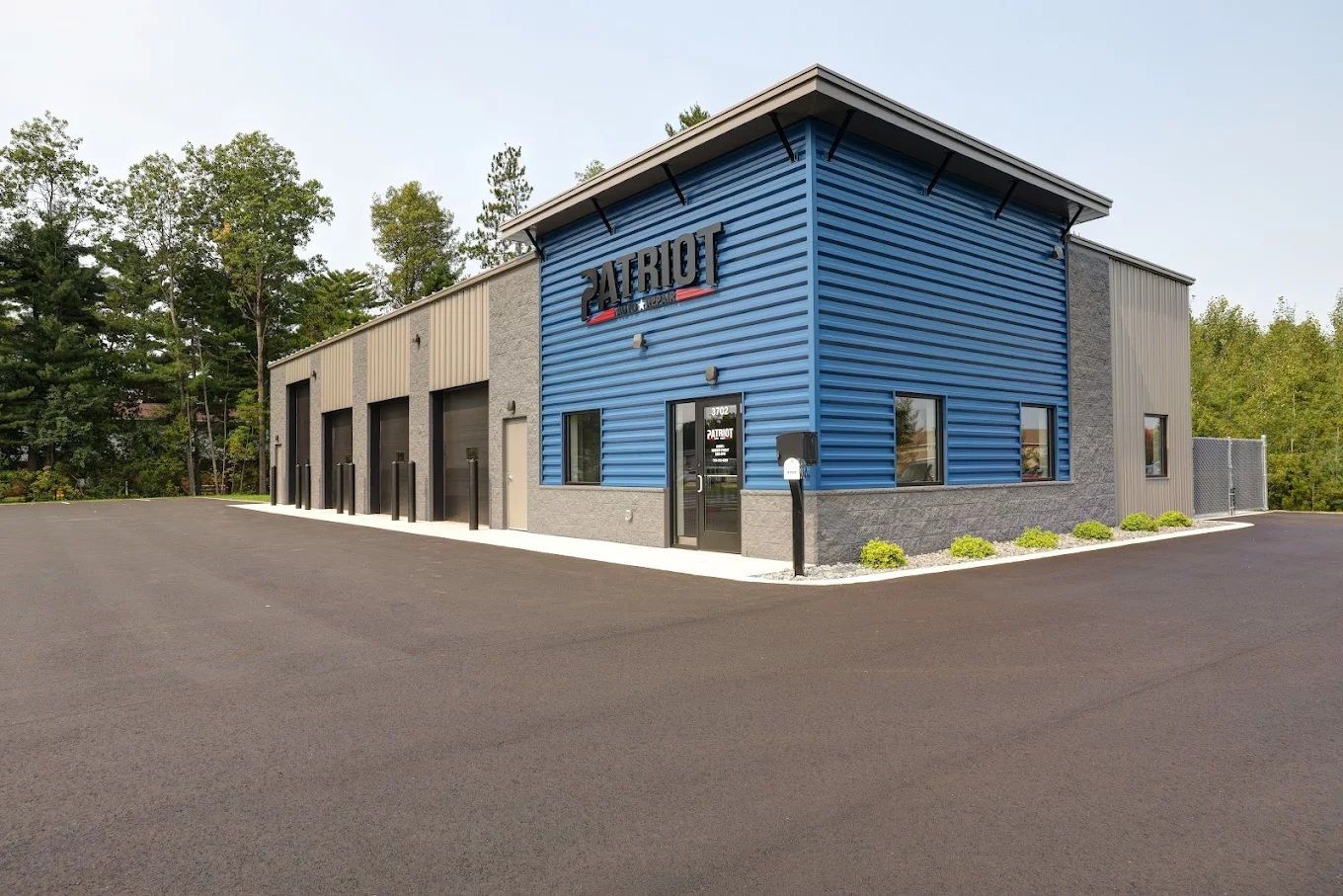A large blue building with a parking lot in front of it.