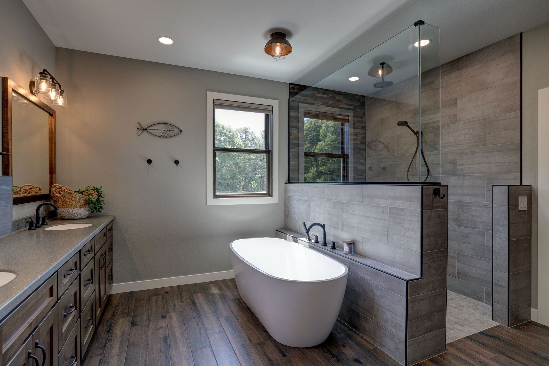 A bathroom with a tub , sink , mirror and walk in shower.