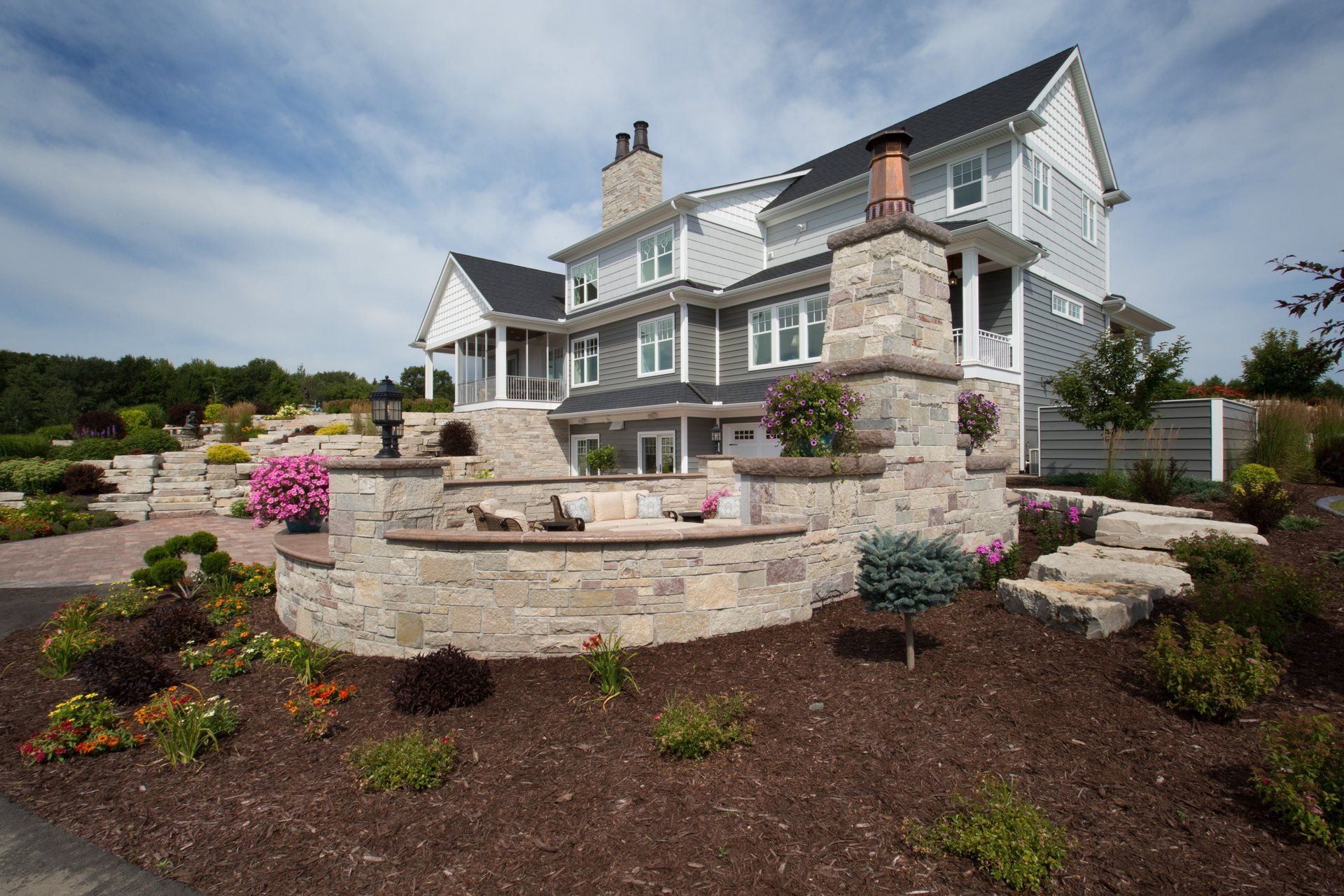 A large house with a stone wall in front of it