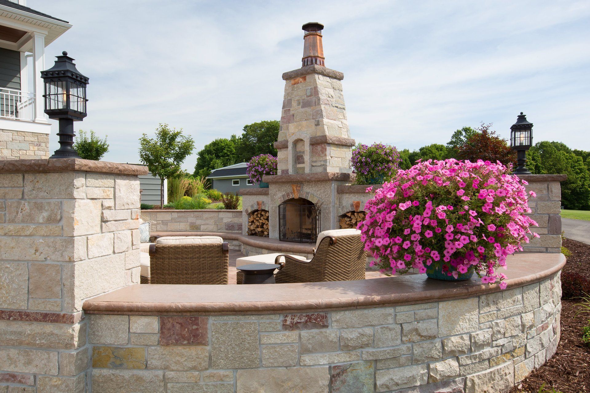 A brick wall with pink flowers and a fireplace in the background