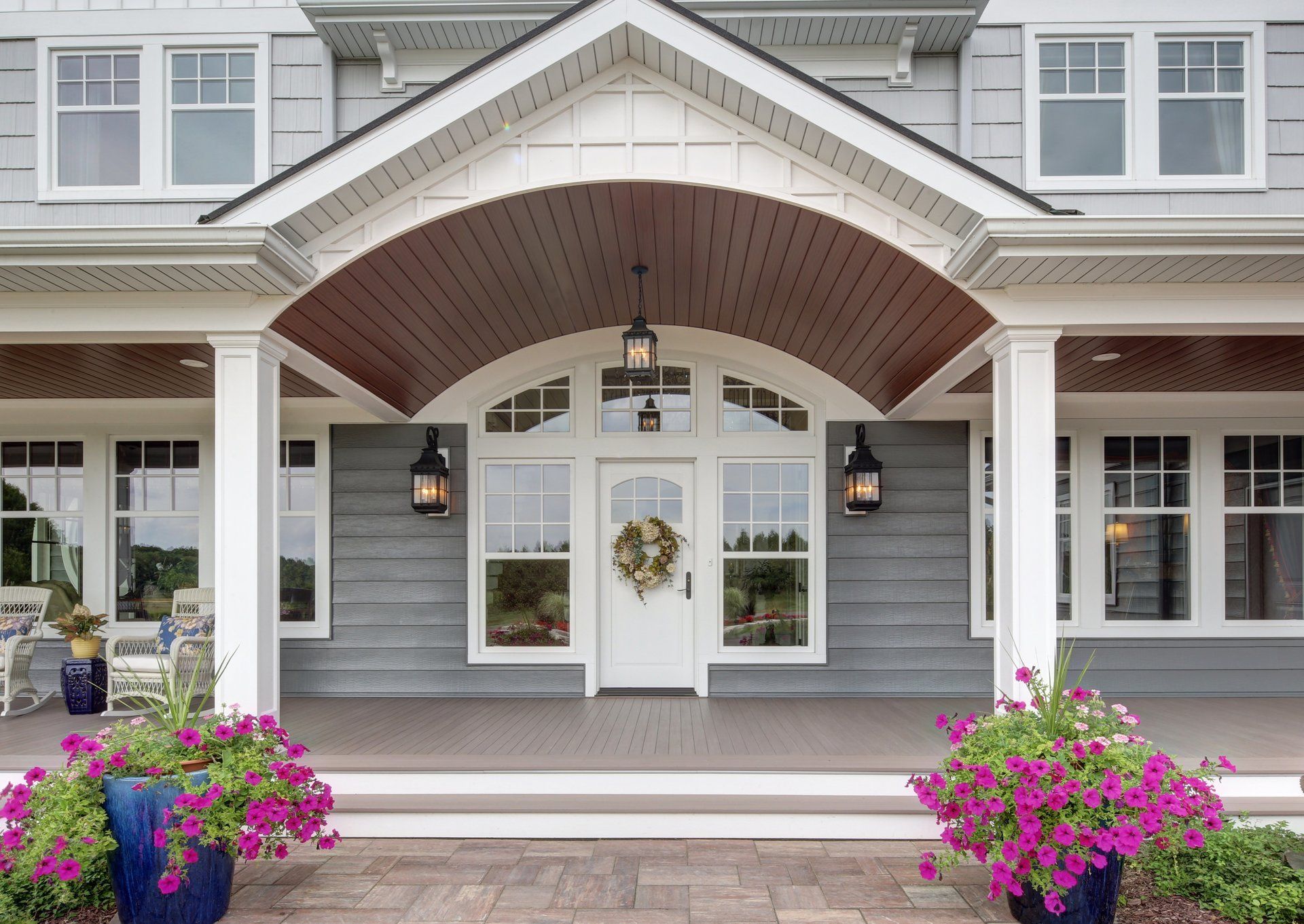 A large house with a porch and flowers in front of it