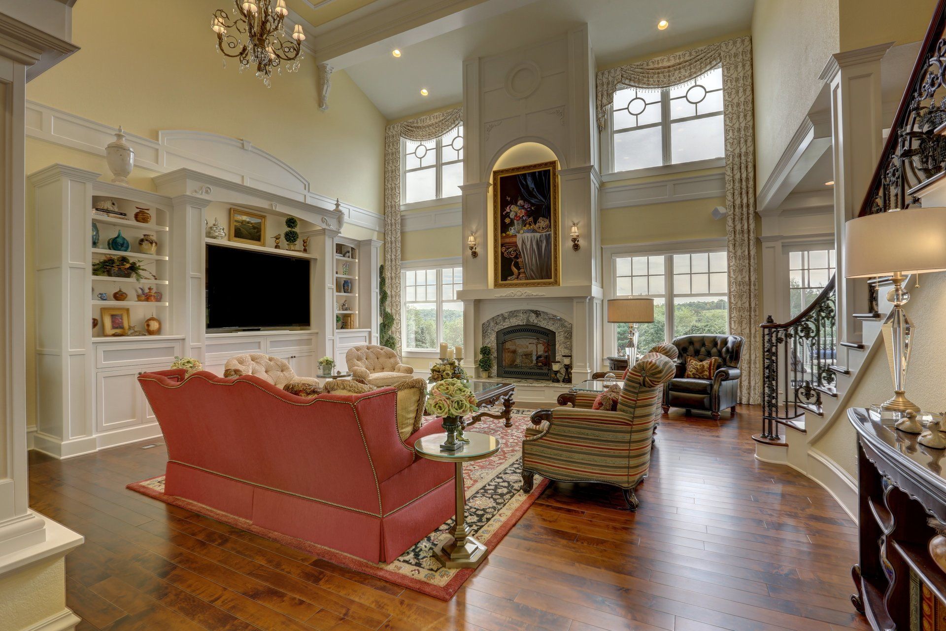 A living room with a red couch , chairs , television and fireplace.
