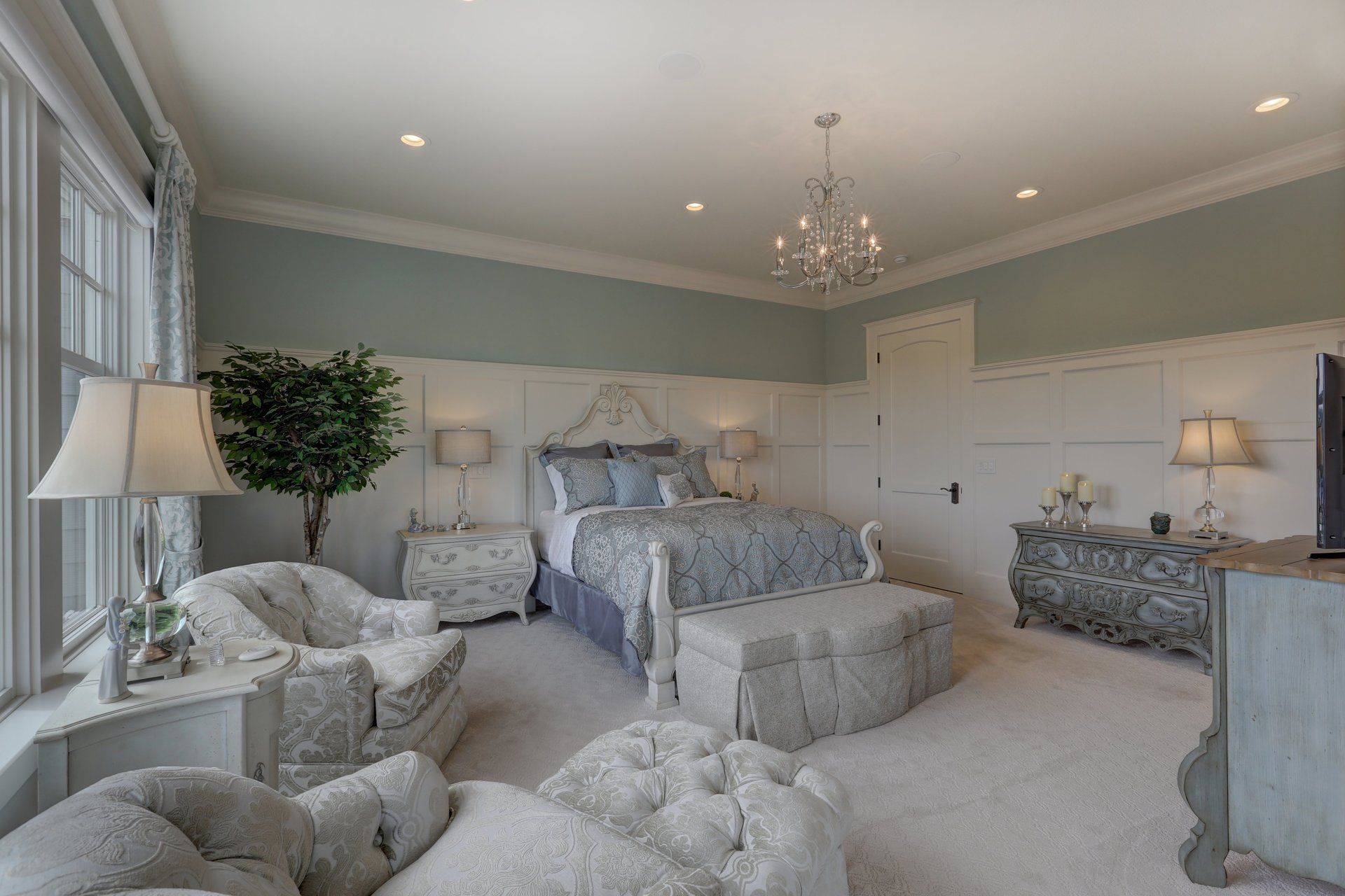 A bedroom with a bed , chairs , dresser , and television.