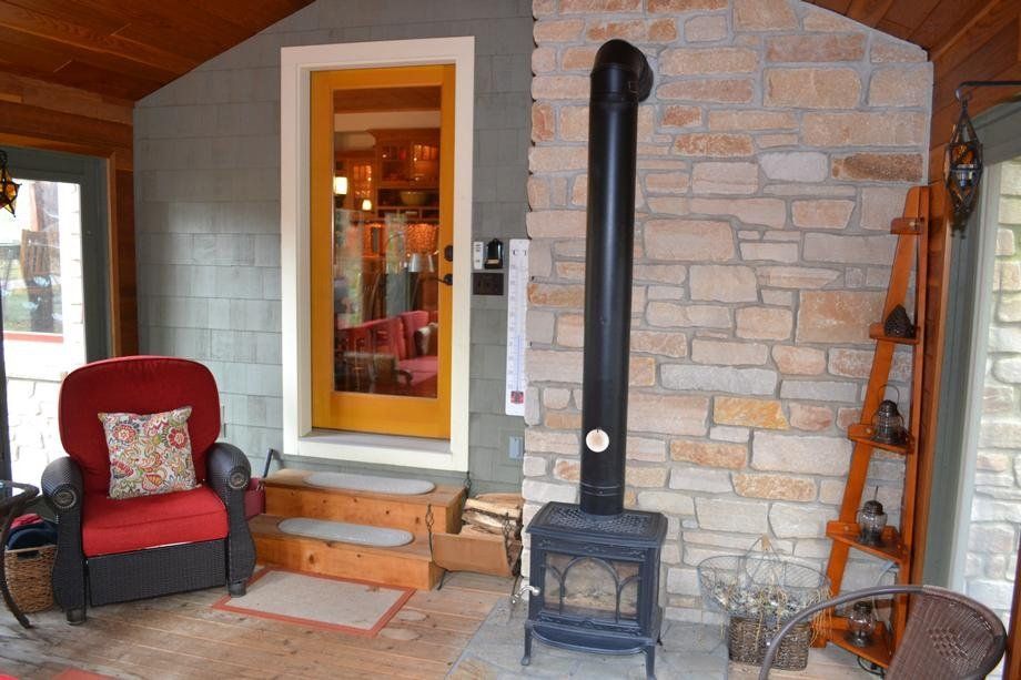 A living room with a wood stove and a chair