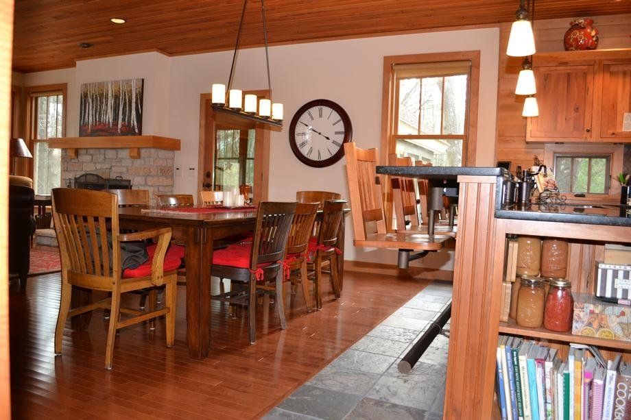 A dining room with a table and chairs and a clock on the wall