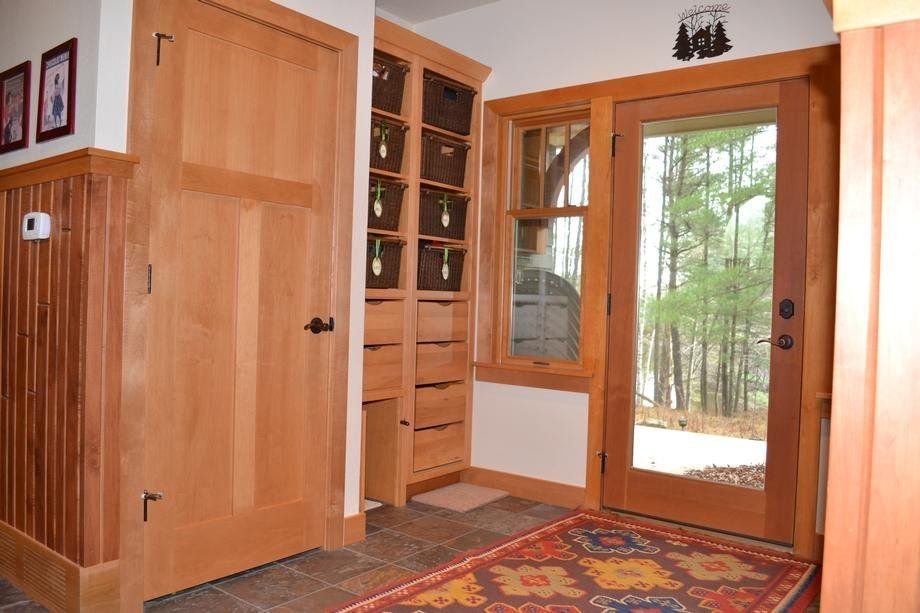 A hallway in a house with a rug and a door