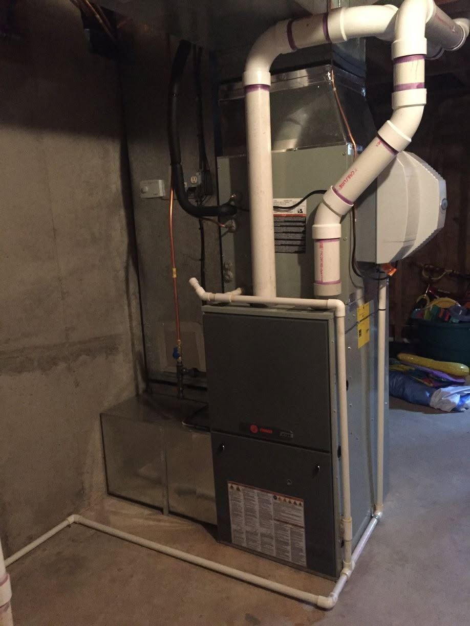 Furnace and HVAC ductwork in a basement utility area